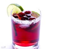 a red drink with lime and cherries in it