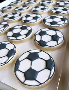 cookies decorated with black and white soccer balls are sitting on a baking sheet, ready to be baked