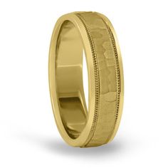 an 18k yellow gold wedding ring with engraved details on the outside and inside sides