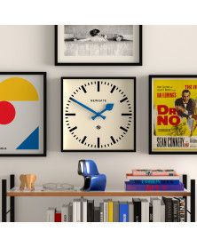 three framed movies hang on the wall above a bookshelf with posters and a clock