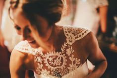 a woman in a wedding dress cutting into a cake