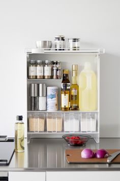 an organized kitchen counter with spices, condiments and other items on the shelf