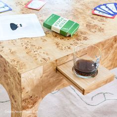 an apple book sitting on top of a wooden table next to a glass filled with liquid