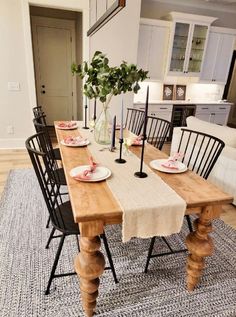 a dining room table is set with plates and place settings