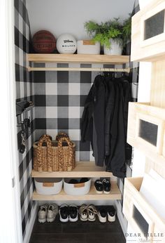 a black and white checkered closet with baskets, shoes and coats on the shelves