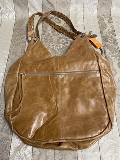 "X-Large size NWT smooth tan leather tote/handbag. Closure is a zipper. Use with built in straps or connect over the shoulder strap included. Interior lining is a cute cotton floral pattern. Great condition, 5 on level 1-5. Please look at pictures. Never used. Size is 17\"x 16\"x 10\" (Inches). Has been in storage with no light, no dust and temperature controlled." Light Brown Hobo Tote Bag, Light Brown Hobo Tote Bag For Errands, Light Brown Shoulder Bag With Zipper Closure, Brown Hobo Shoulder Bag With Zipper Closure, Travel Hobo Bag In Soft Light Brown Leather, Light Brown Shoulder Bag With Zipper For Travel, Light Brown Travel Shoulder Bag With Zipper, Light Brown Soft Leather Hobo Bag For Travel, Cognac Hobo Bag With Adjustable Strap And Double Handle