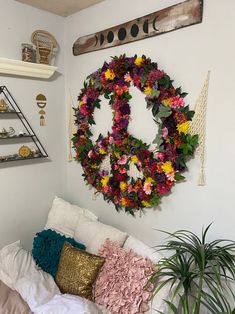 a wreath is hanging on the wall above a bed with pillows and throw pillows in front of it