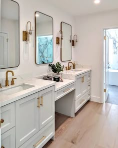 a white bathroom with two sinks and mirrors