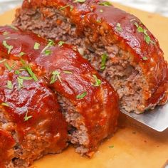 meatloaf with sauce and parsley on cutting board ready to be cut up