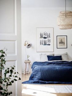 a bedroom with white walls and blue bedding