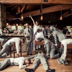 a group of men in suits and ties are posing for a photo with one man on the floor