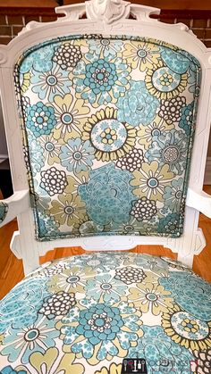 an upholstered chair with blue and yellow flowers on it