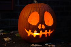 a carved pumpkin sitting on top of a table with its eyes glowing in the dark