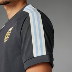 Who would have guessed that a team could have looked so upscale until the adidas Argentina 3-Stripe Men's Tee debuted? The sophisticated Argentina emblem truly gives this shirt a hint of class that a standard tee just doesn't have. And for those who live and breathe the adidas brand, you still get the logo and striped design they're known for. Slim fit; hugs the body. Ribbed crewneck and cuffs make for a snug fit. Short raglan sleeves. Iconic embroidered Trefoil logo on chest. 3-stripes down sho Sports Season Three Stripes Crew Neck T-shirt, Adidas Three Stripes Streetwear T-shirt, Collegiate Black Tops With Three Stripes, Casual Three Stripes T-shirt For Sports Events, Sporty Striped Crew Neck T-shirt, Black Varsity Top With Three Stripes, Black Jersey Tops With Three Stripes, Black Jersey Top With Three Stripes, Sporty Short Sleeve T-shirt With Side Stripes