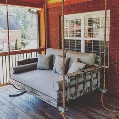 a porch swing bed with pillows on it