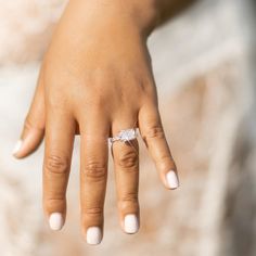 a woman's hand with a diamond ring on it