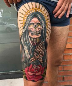 a man's thigh with a tattoo on it and a skeleton holding a rose