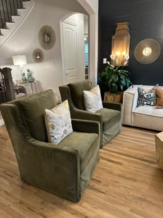 a living room filled with furniture and a stair case in front of the couches