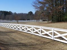 a white fence in the middle of a field