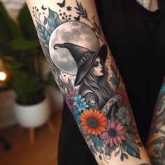 a woman wearing a witches hat with flowers on her arm