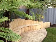 a wooden bench sitting next to a lush green tree