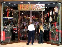 two people standing in front of a clothing store