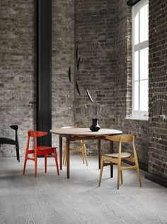 two chairs and a table in front of a brick wall