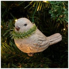 a bird ornament hanging from a christmas tree with lights on it's head