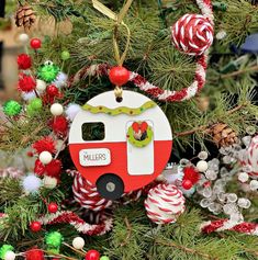 a christmas ornament hanging from a tree with candy canes and ornaments around it