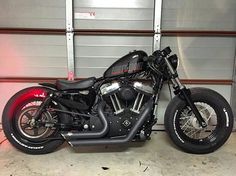 a black motorcycle parked in front of a garage door