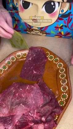 a person cutting up some meat on a plate