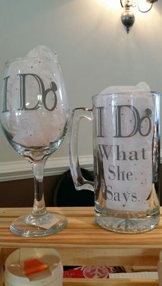 two glass mugs sitting on top of a wooden table next to bottles and glasses