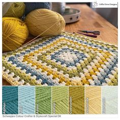 a crocheted rug with different colors and yarns on the table next to it