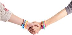 two people holding hands with bracelets on their wrists