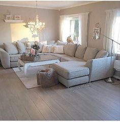 a living room filled with lots of furniture and a chandelier hanging from the ceiling