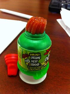 a bottle of ketchup sitting on top of a wooden desk