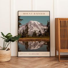 a mountain is reflected in the water near a potted plant and a wooden chair