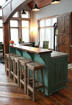 a kitchen with an island and stools next to it in the middle of a room