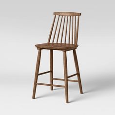 a wooden bar stool with a bent back and slatted seat on an isolated white background