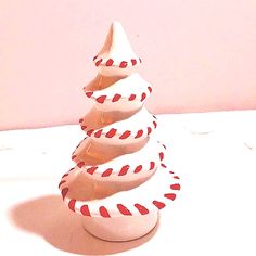 a white ceramic christmas tree with red and white stripes