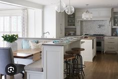 a kitchen with an island and stools next to the counter top in front of it