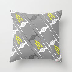 a gray and yellow pillow with some black and white designs on the front, along with two yellow lines