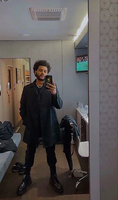 a man is taking a selfie in the mirror with his cell phone and shoes