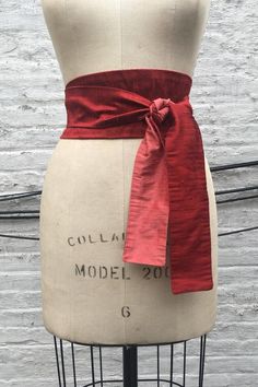 This modern interpretation of an obi sash is made in two colors of silk shantung.Shown in a rich ruby red reversing to vibrant coral.The sash provides an instant update to your wardrobe - add to a basic black dress or pair it with a tunic tee and jeans. It can be worn wrapped and tied in the front (as shown) or tied in the back. It's the ultimate must-have accessory!Widest part approx. 3 1/2"Tie ends approx. 2 1/4"Available in 3 lengths:80" long - fit up to a 32" waist when wrapped & tied in fro Obi Sash, Hex Girls, Basic Black Dress, Star Wars Halloween, Ball Gown Skirt, Gold Silk, Beautiful Skirts, Fabric Belt, Suspender Belt