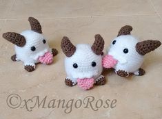 three small stuffed animals sitting on top of a tile floor