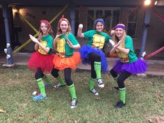 three girls dressed in teenage mutant costumes posing for the camera with their hands up and one girl wearing turtle costume