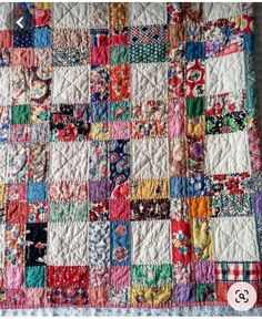 a colorful quilt with many different colors and designs on the front, along with a white background