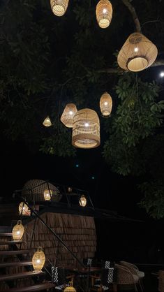 several lights hanging from the ceiling above a set of stairs in front of a tree