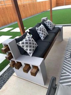 a couch sitting on top of a wooden bench next to a green grass covered field