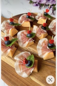 small appetizers are arranged on a wooden platter